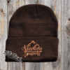 Dark brown beanie with adventure awaits embroidered on it