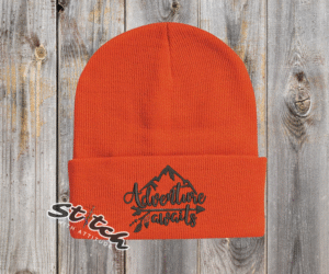 Orange beanie with adventure awaits embroidered on it