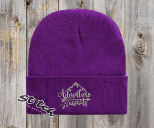 Purple beanie with adventure awaits embroidered on it