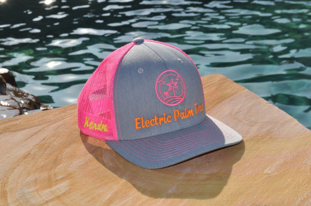Bright pink and gray hat with logo embroidered on the front