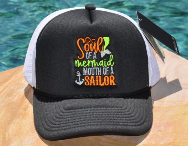 Black and white foam trucker hat with "Sour of a mermaid mouth of a sailor" embroidered on the front
