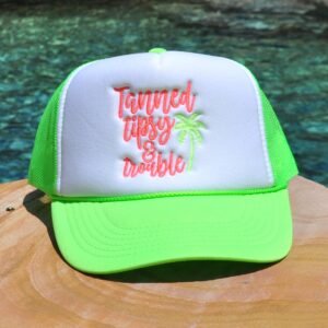 Neon green and white foam trucker hat with "Tanned, Tipsy and Trouble" embroidered on the front