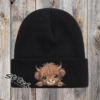 Baby highland cow on a black beanie