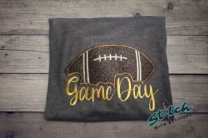 Game Day Glitter Football Embroidered Sweatshirt. You already live at the field. This is what you wear there. A glitter football applique, Game Day in stitched script, and the thre