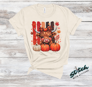 Highland Cow Fall Pumpkin Rhinestone Tee. A shaggy little cow in a plaid bow, three pumpkins, and real rhinestones set by hand. Fall, wearing it loudly.