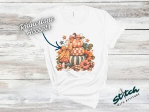 Stacked Pumpkins Fall Tee with Rhinestone Accents - Stacked-Pumpkins-Rhinestone-Tee-2.jpg Stacked Pumpkins Fall Tee with Rhinestone Accents. Three painted pumpkins under a gingham bow, with mushrooms, sunflowers and stars, and real rhinestones set by hand across the des