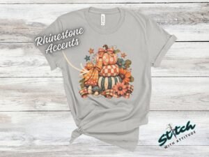 Stacked Pumpkins Fall Tee with Rhinestone Accents - Stacked-Pumpkins-Rhinestone-Tee-3.jpg Stacked Pumpkins Fall Tee with Rhinestone Accents. Three painted pumpkins under a gingham bow, with mushrooms, sunflowers and stars, and real rhinestones set by hand across the des