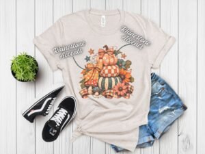 Stacked Pumpkins Fall Tee with Rhinestone Accents - Stacked-Pumpkins-Rhinestone-Tee-4.jpg Stacked Pumpkins Fall Tee with Rhinestone Accents. Three painted pumpkins under a gingham bow, with mushrooms, sunflowers and stars, and real rhinestones set by hand across the des
