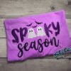 Spooky Season Glitter Ghost Applique Tee. SPOOKY in dark purple glitter, two little glitter ghosts standing in for the double O, and Season stitched in script underneath. Bats incl