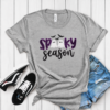 Spooky Season Glitter Ghost Applique Tee. SPOOKY in dark purple glitter, two little glitter ghosts standing in for the double O, and Season stitched in script underneath. Bats incl