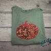 Sequin Pumpkin Applique Sweatshirt Sequin pumpkin applique fall sweatshirt with embroidered stem on a green garment